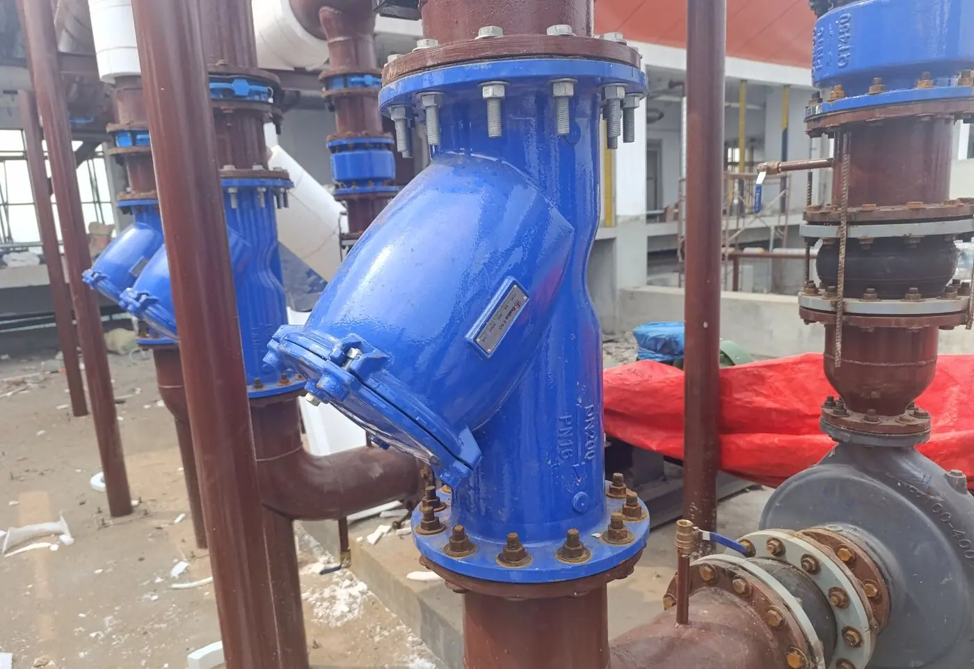 Blue chilled-water valve and strainer set on rooftop pipework