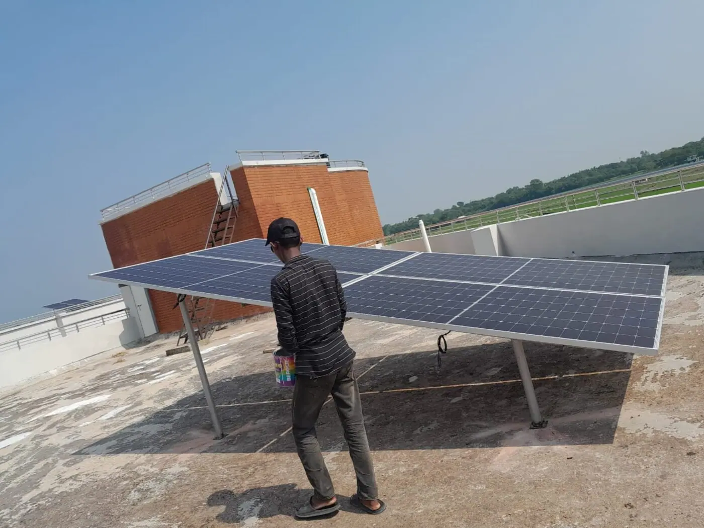 Technician at a rooftop solar array on a campus building